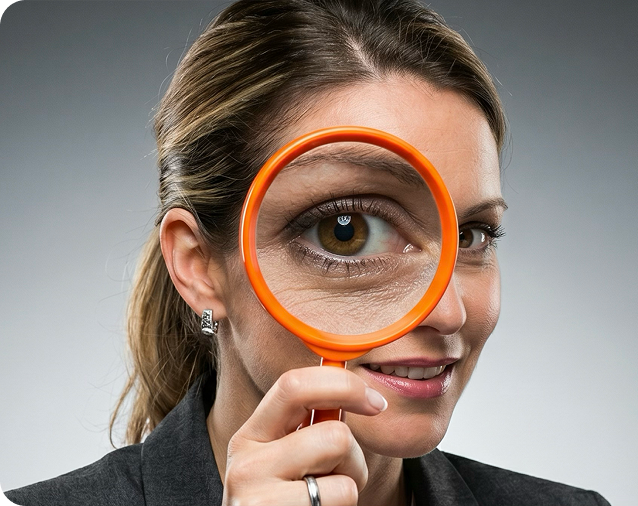 Woman looking through an orange magnifying glass